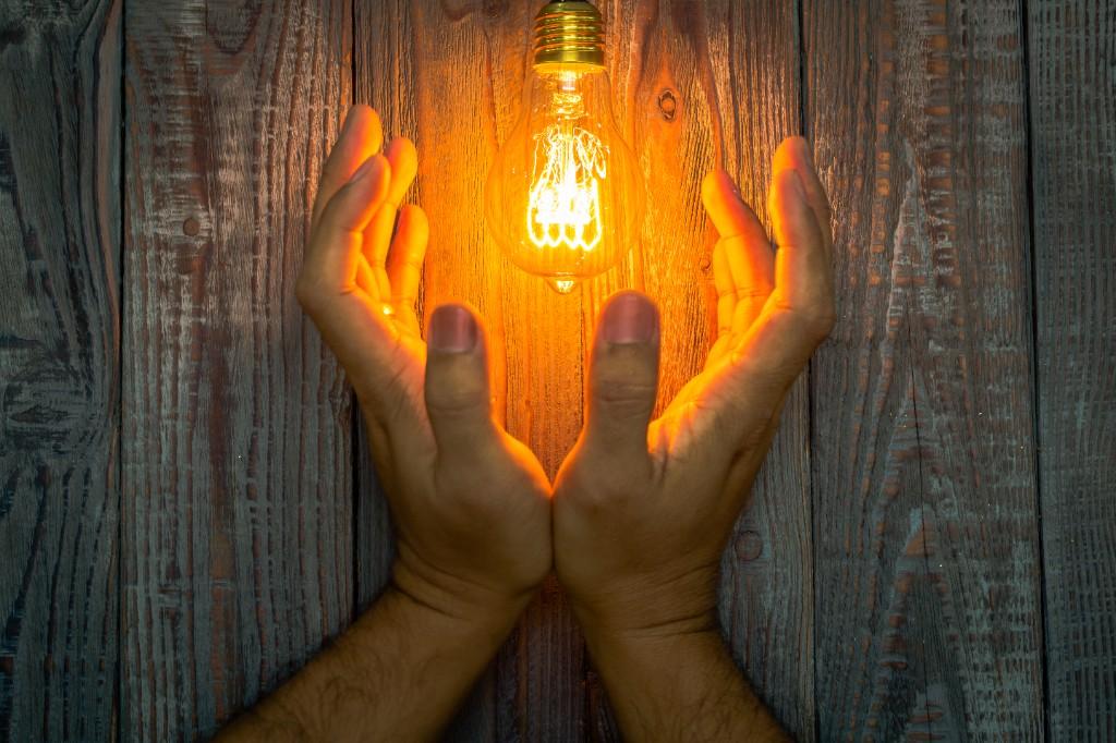 Mains tenant une lumière dorée — symbole du magnétisme et de l'énergie transmise